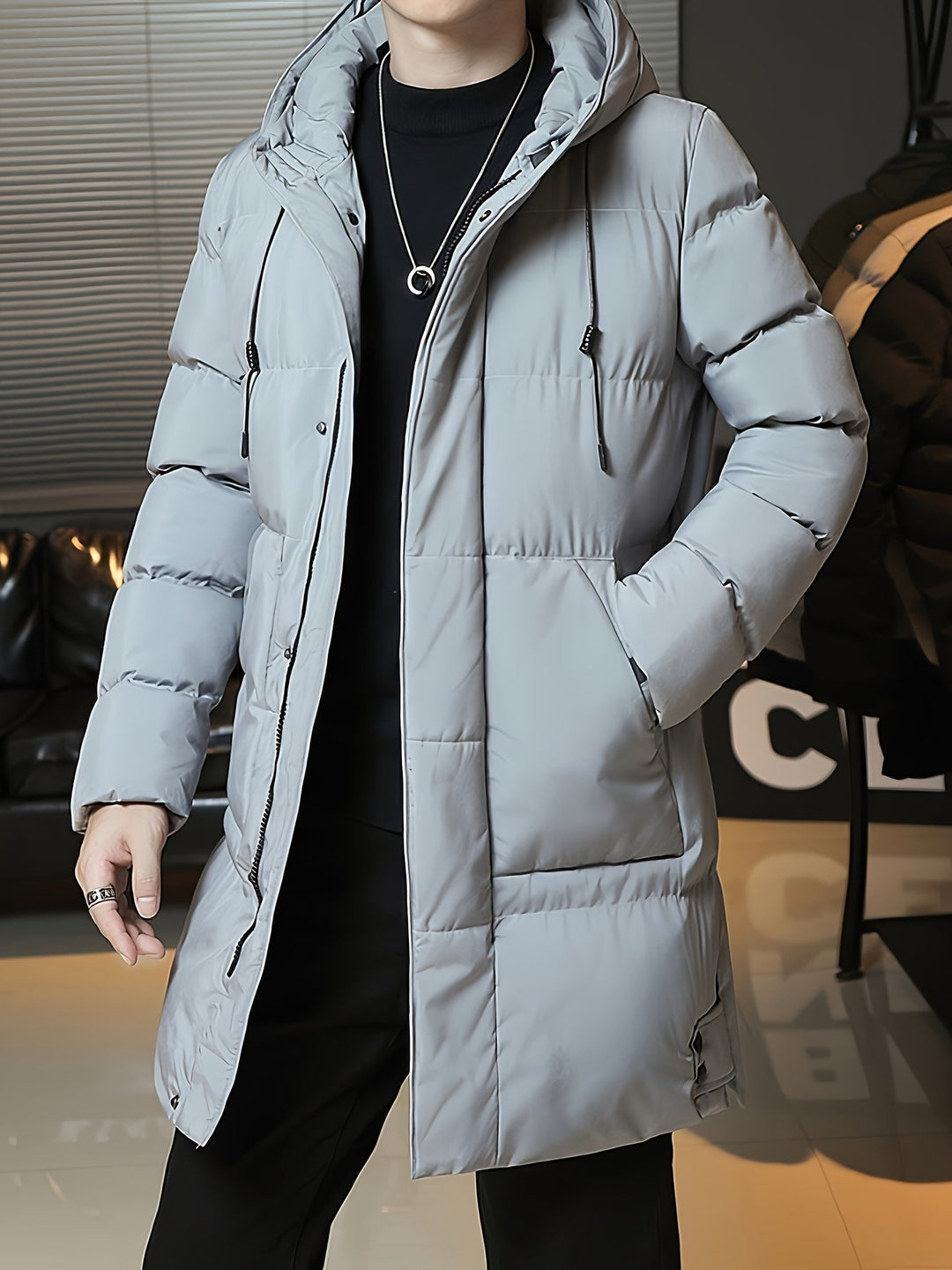 Man wearing Barnaby grey longline coat, holding phone