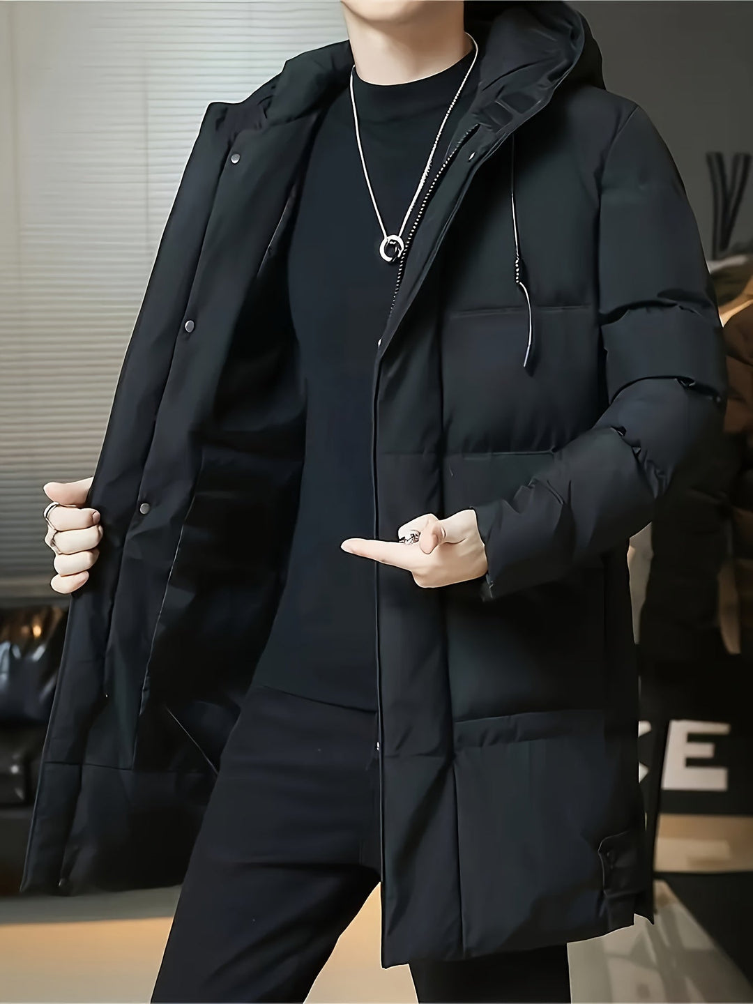 Man wearing Barnaby black longline coat open, holding lapel