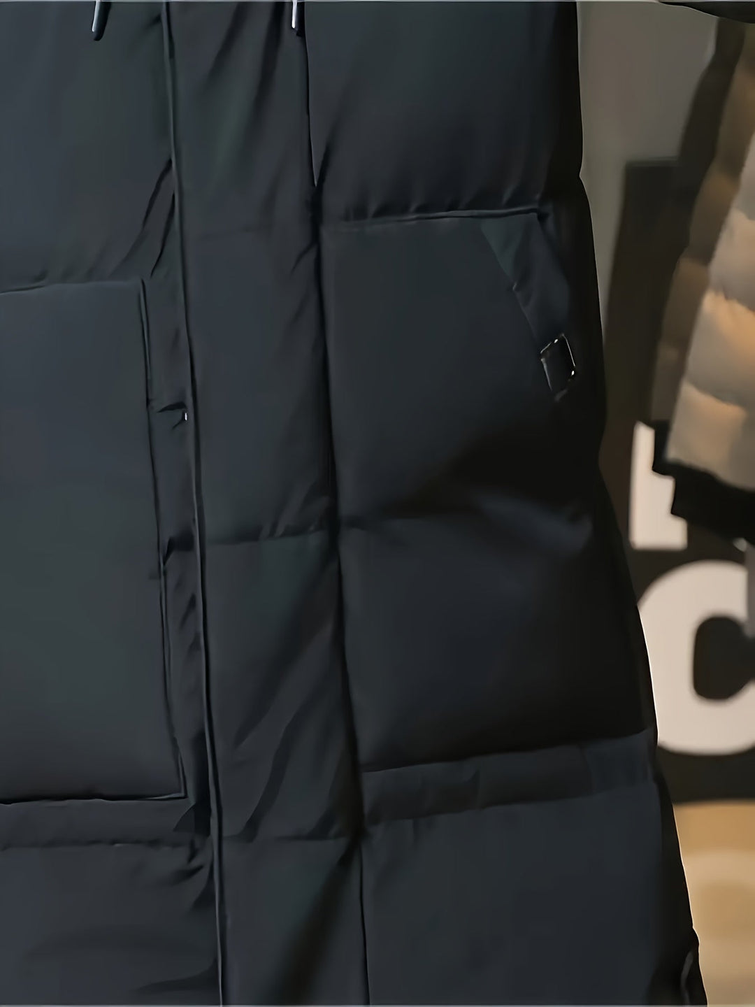 Detail of Barnaby black coat pocket and side tab closure