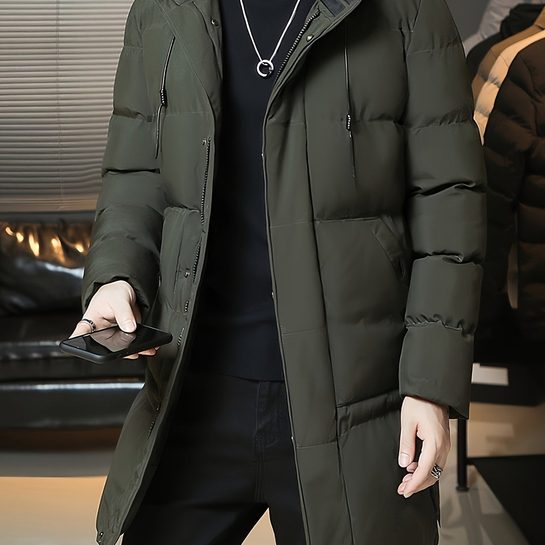 Barnaby hooded longline puffer coat in green, front view with phone in hand