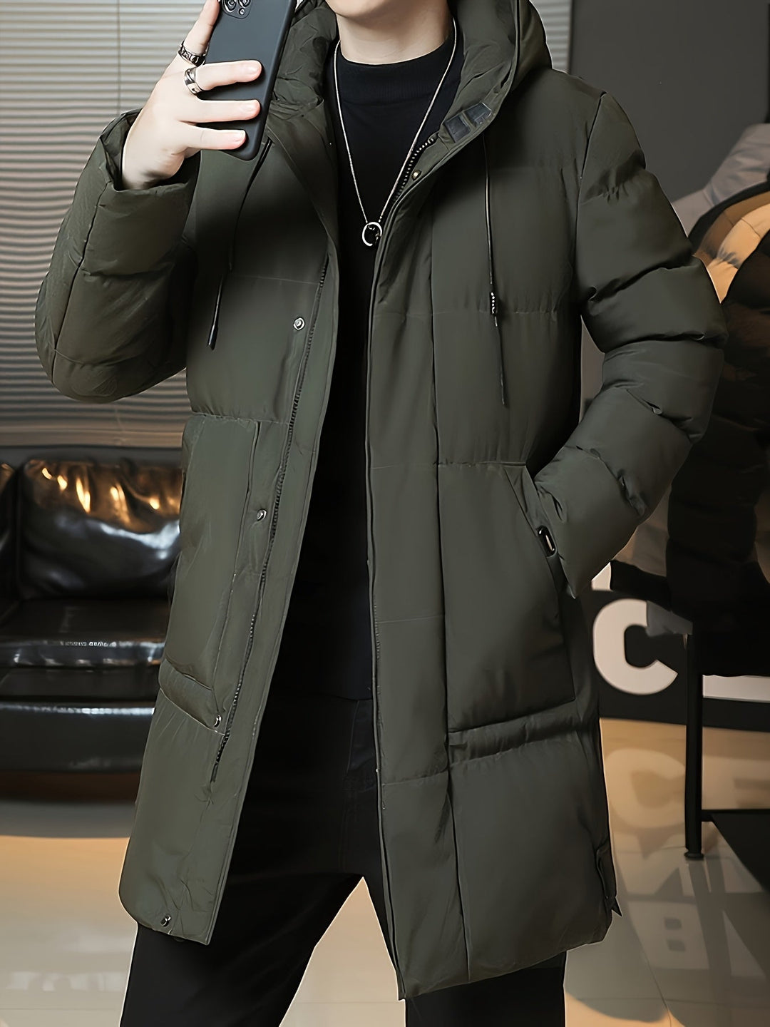Man wearing Barnaby green longline coat, hands in pockets