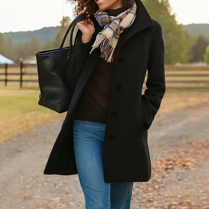 Cecily classic single-breasted mid-length coat in black, front view with scarf and tote bag