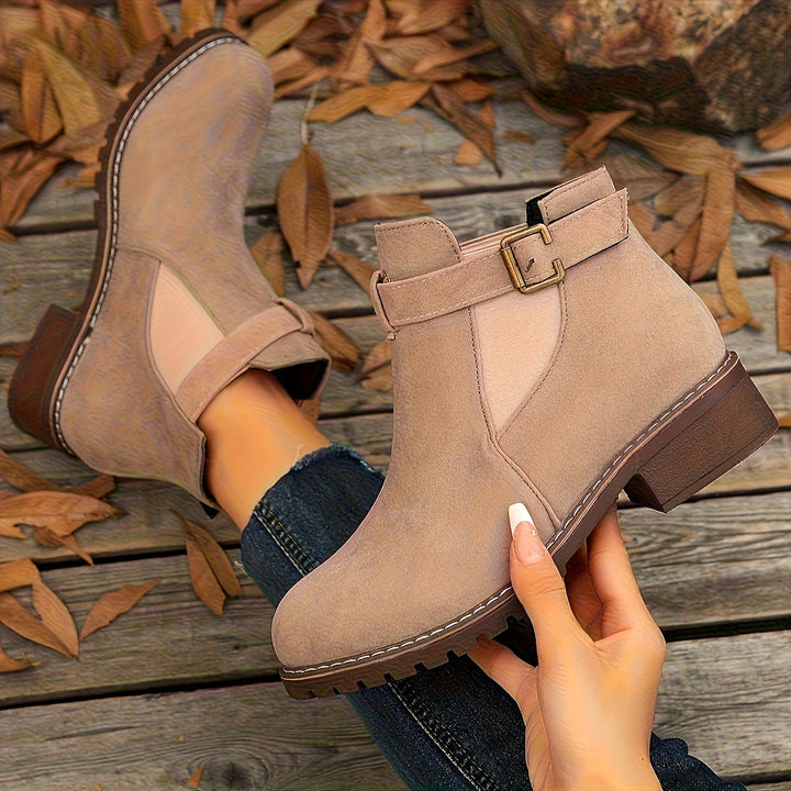 Marigold buckle strap Chelsea boots in taupe, held by hand