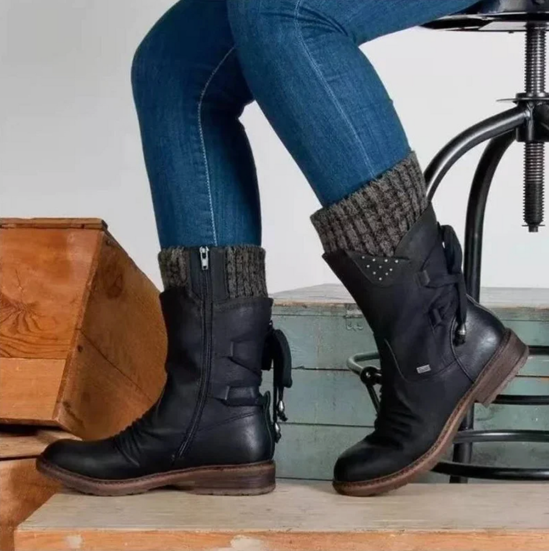 Perpetua black knit cuff boots worn on both feet, side profile