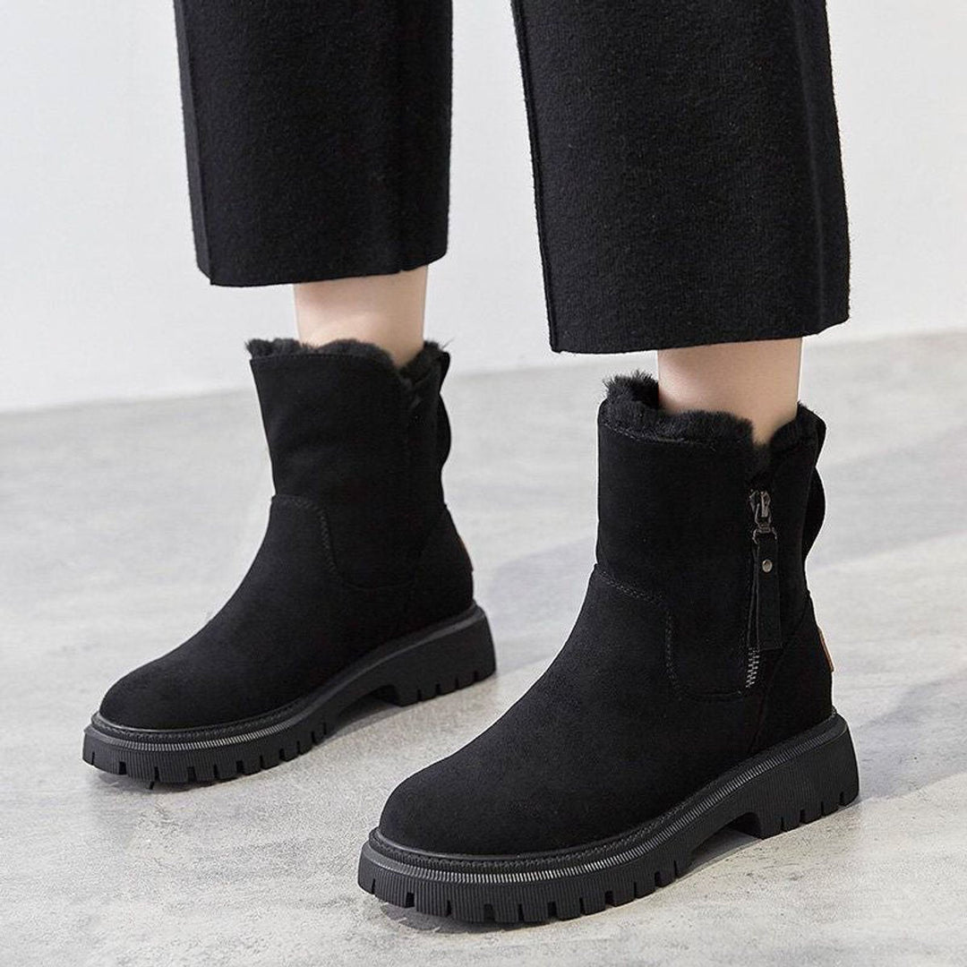 Primrose slip-on ankle boots worn on model with black trousers, front view