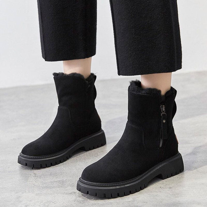 Primrose slip-on ankle boots worn on model with black trousers, front view