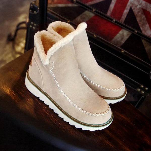 Rosalie fleece lined ankle boots in pale pink, pair on wooden table