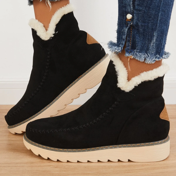 Rosalie fleece lined ankle boots in black, side view worn with jeans
