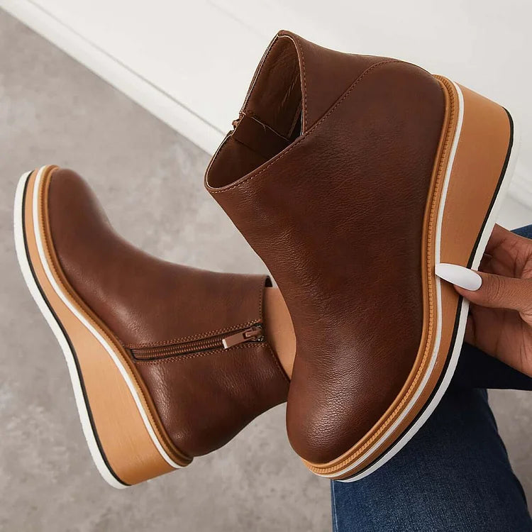 Rosalie brown wedge platform ankle boots held by hand, sole detail