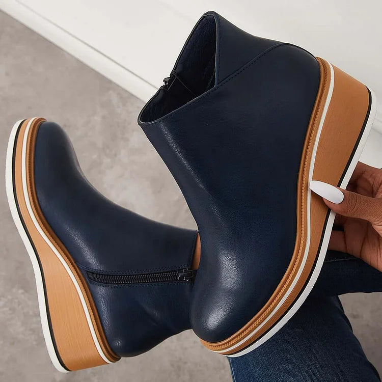 Rosalie navy wedge platform ankle boots held by hand, sole detail