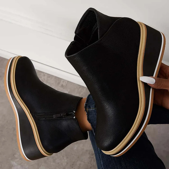 Rosalie black wedge platform ankle boots held by hand, sole detail