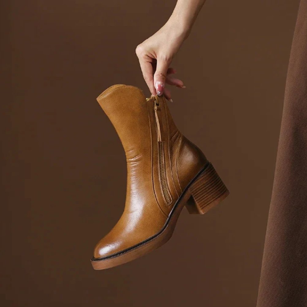 Rosalind ankle boot held by hand showing side zip and heel detail