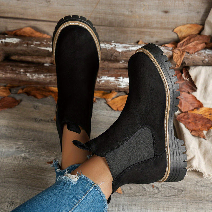 Black chunky sole Chelsea boots shown from above, soles facing camera