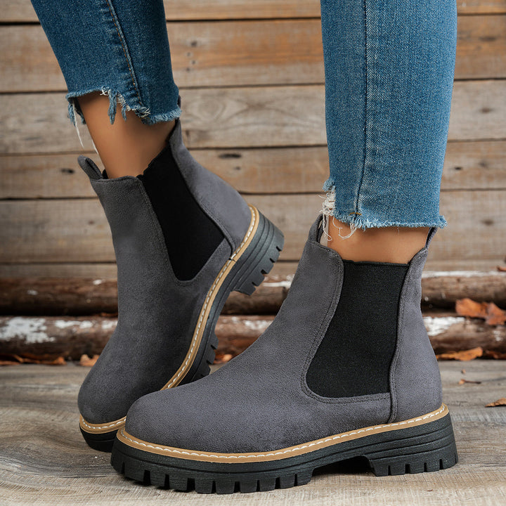 Grey chunky sole Chelsea boots worn with ripped denim jeans
