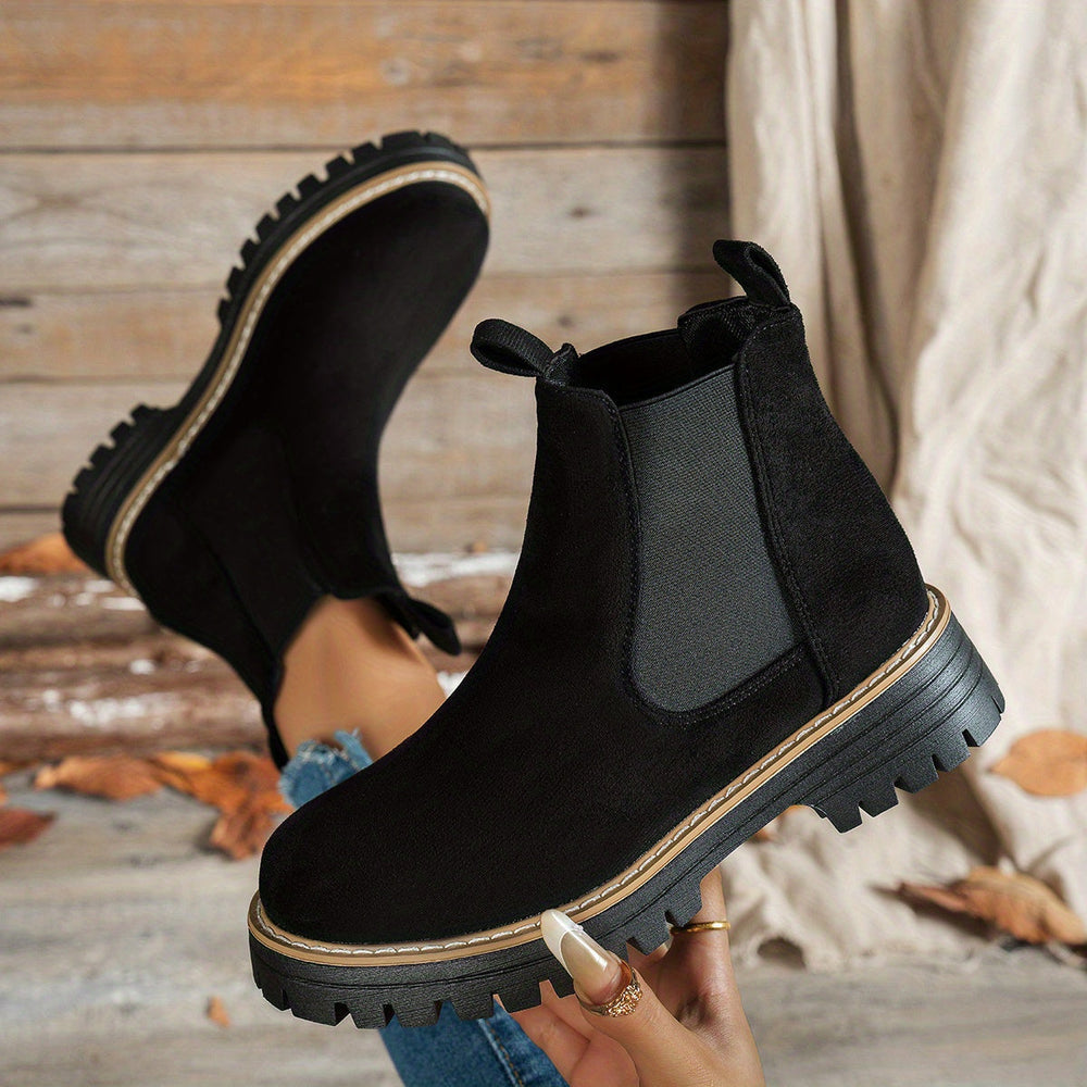 Black Chelsea boots shown from above, soles facing camera