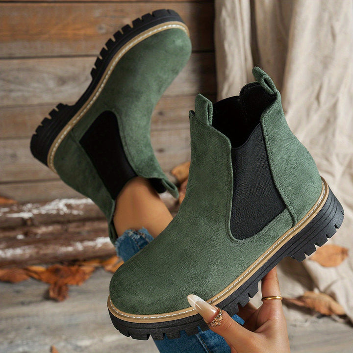 Green Chelsea boots shown from above, soles facing camera